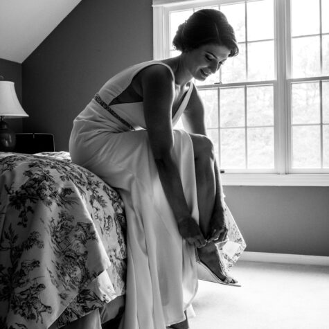 Bride black and white putting shoe on