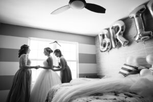 Bride getting dressed with help from mom