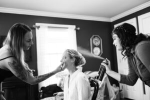 Bride getting makeup done hairspray spraying