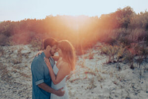 Beach girl and guy kiss on beach sunset