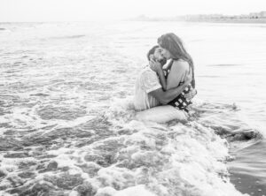 Black and white couple man and women kissing in ocean on beach