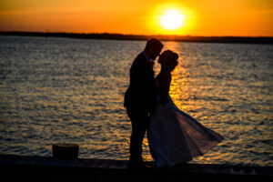 Bride and groom sunset on bay portrait