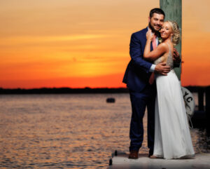 Bride and groom sunset on bay portrait