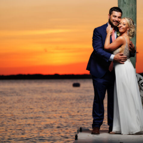 Bride and groom sunset on bay portrait