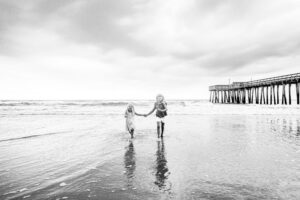 Black and white kids running on beach