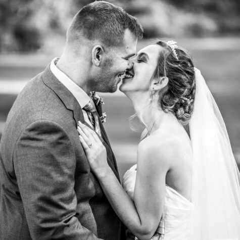 Black and bride bride and groom kissing smiling