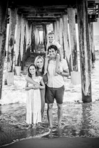 Black and white family under pier on beach