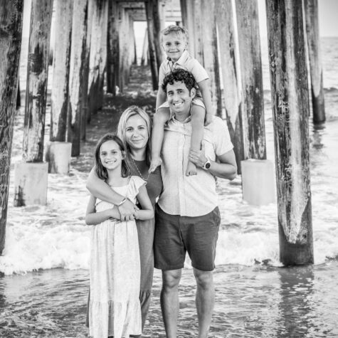 Black and white family under pier on beach