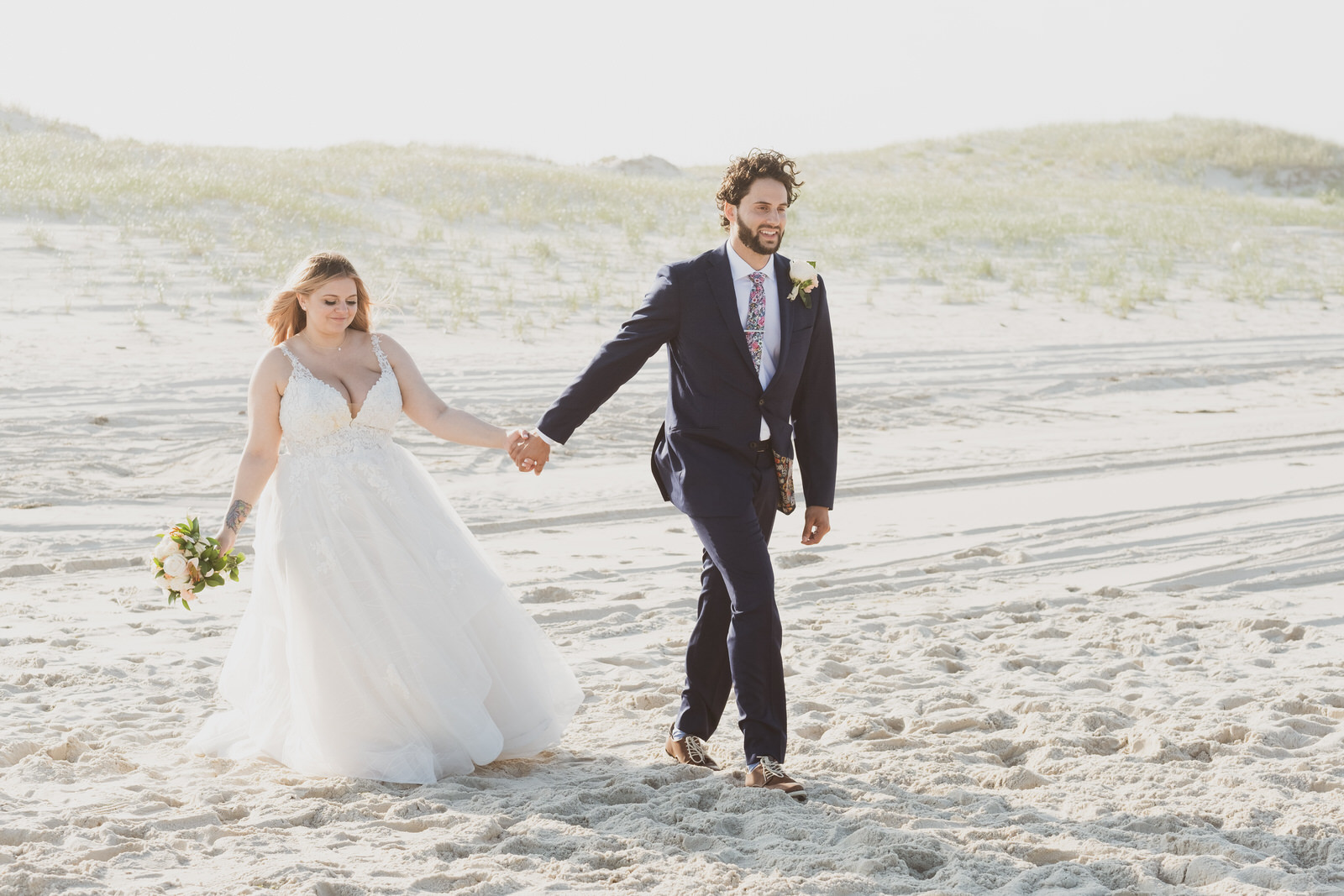 beach wedding couple holding hands walking