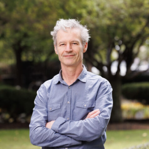Man headshot outdoors green trees background