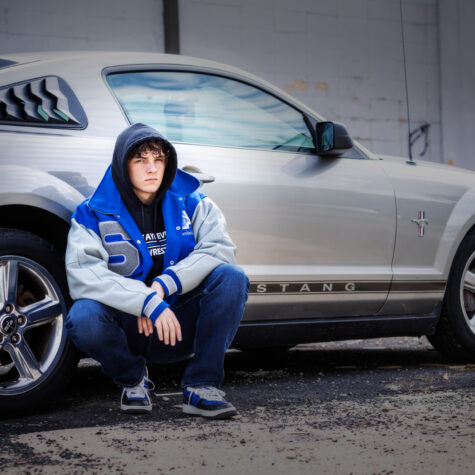 Varsity boy by car