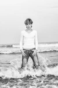 senior boy in ocean in clothes