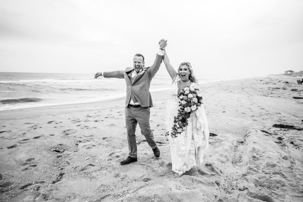 Bride and groom black and white walking beach