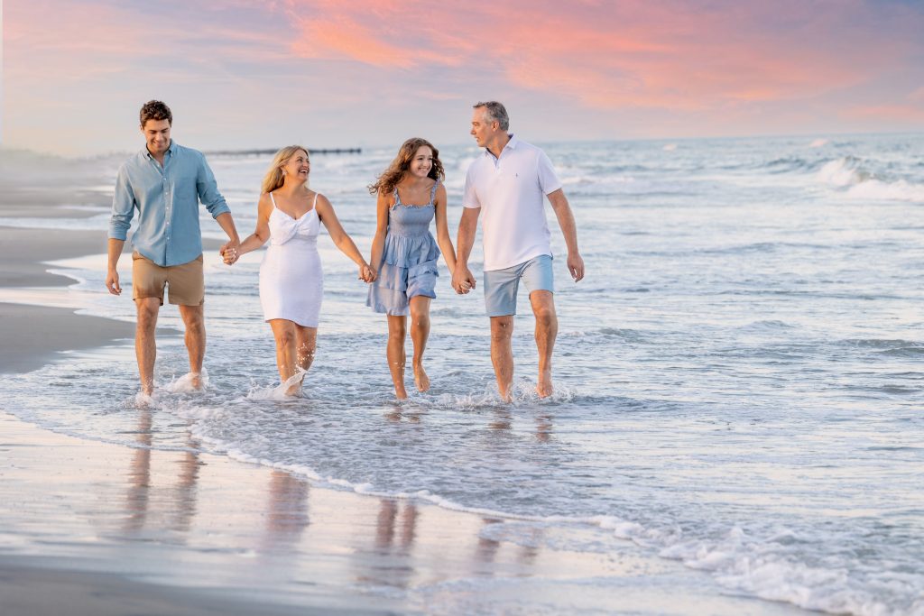 Family walking holding hands along ocean