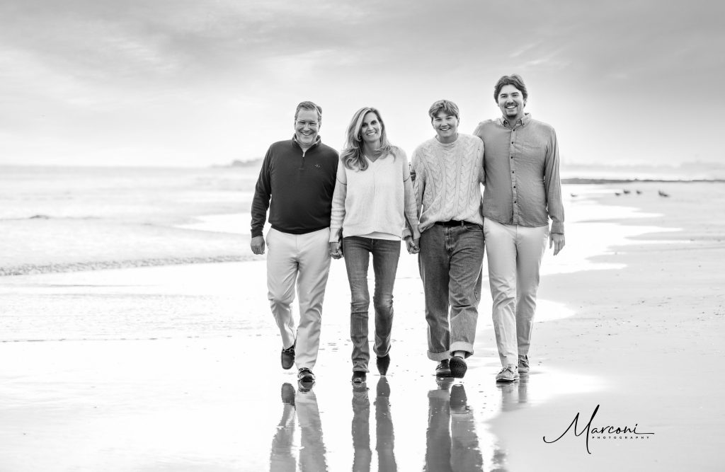 Family walking black and white beach