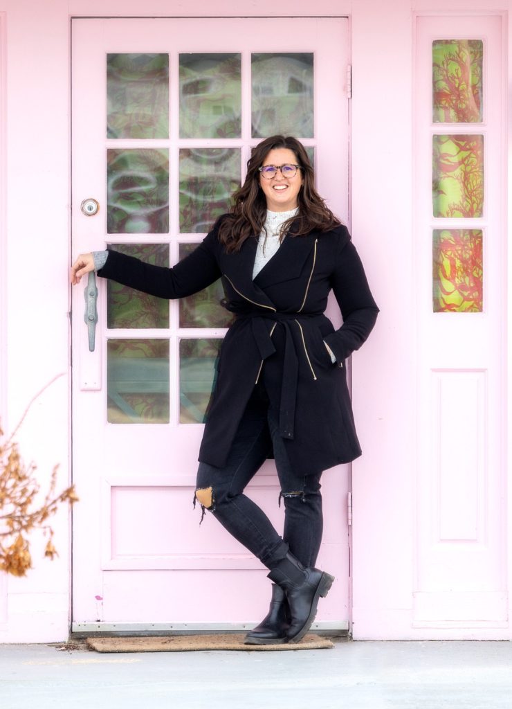 Woman business coach standing by pink door