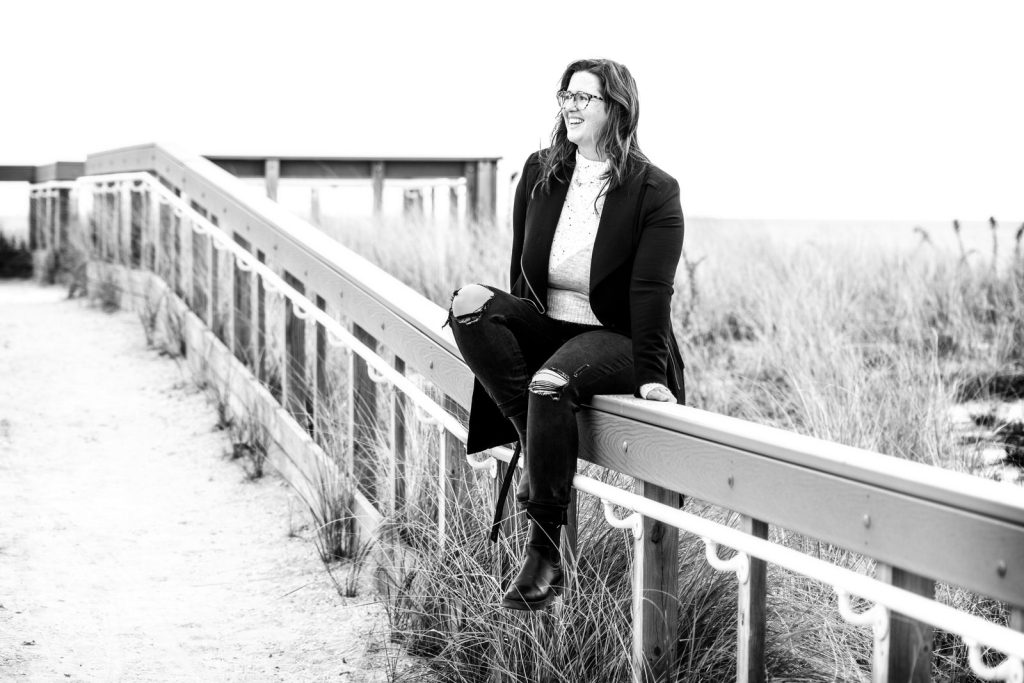 Black and white business coach sitting on beach path in winter 