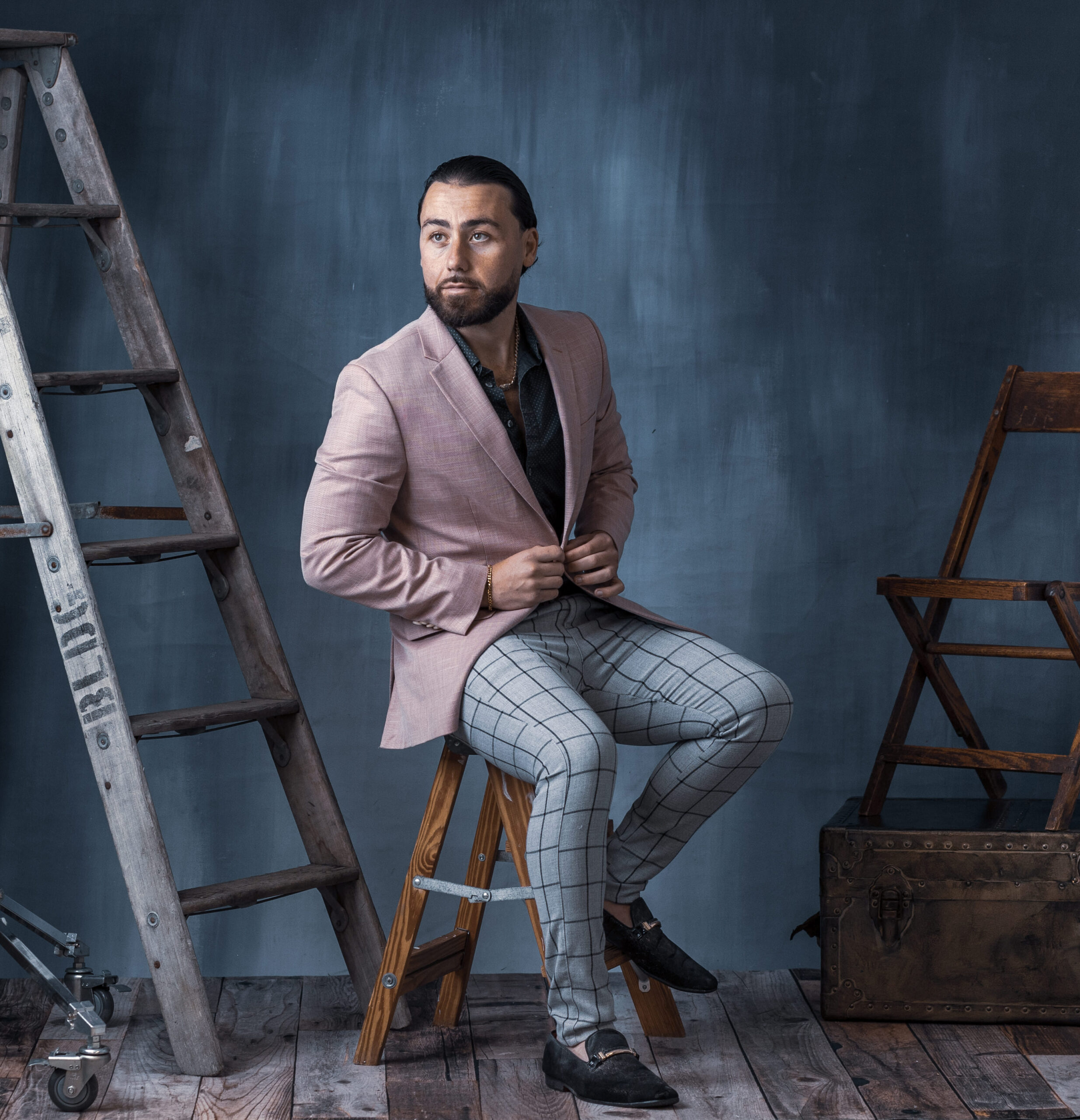 Male sitting on ladder in suit