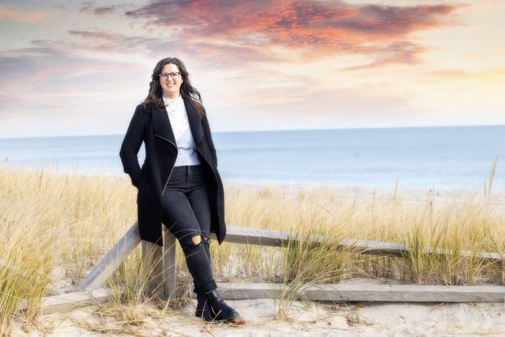 Female in coat standing on beach in winter 