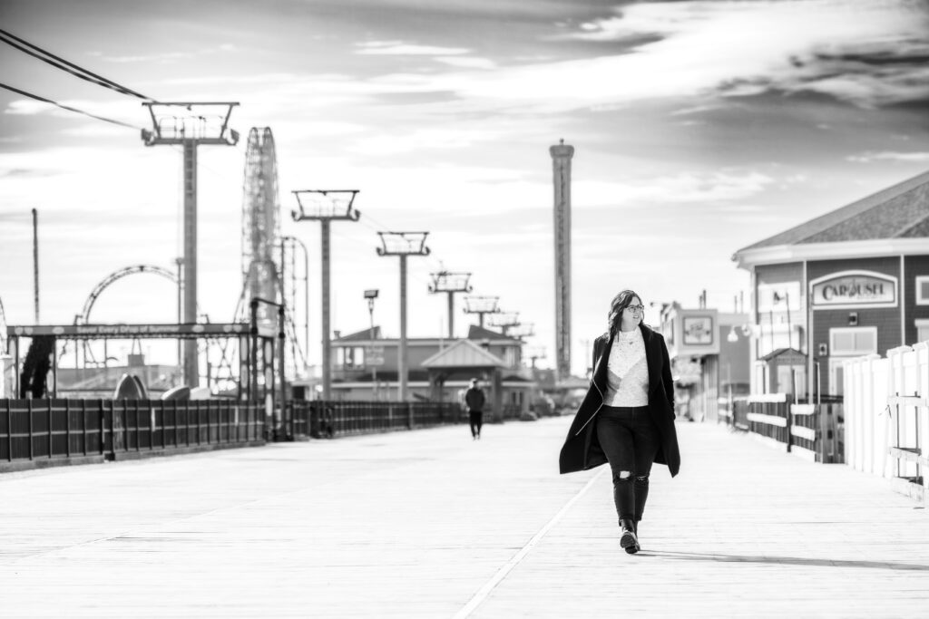 black and white woman walking badass style on boardwalk in seaside nJ