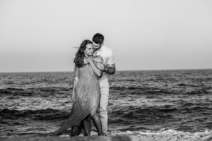 Engaged couple on beach black and white
