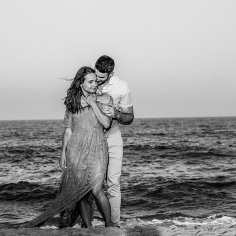 Engaged couple on beach black and white