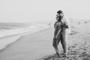 Engaged couple on beach black and white