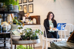 Woman working on laptop in cafe at bistro table
