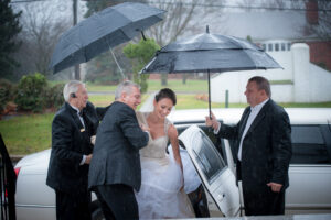 Bride under umbrellas in rain