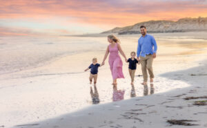 Family walking beach at sunset