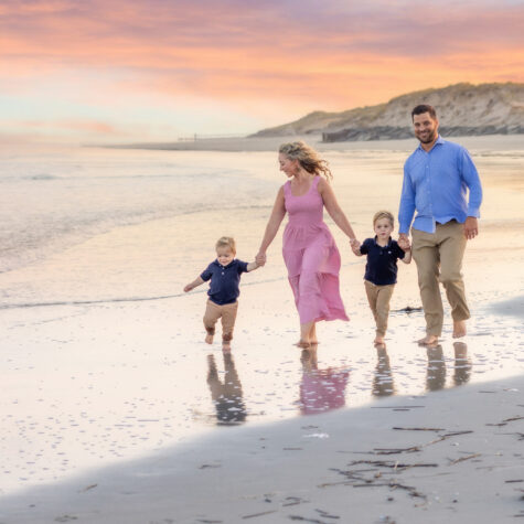 Family walking beach at sunset