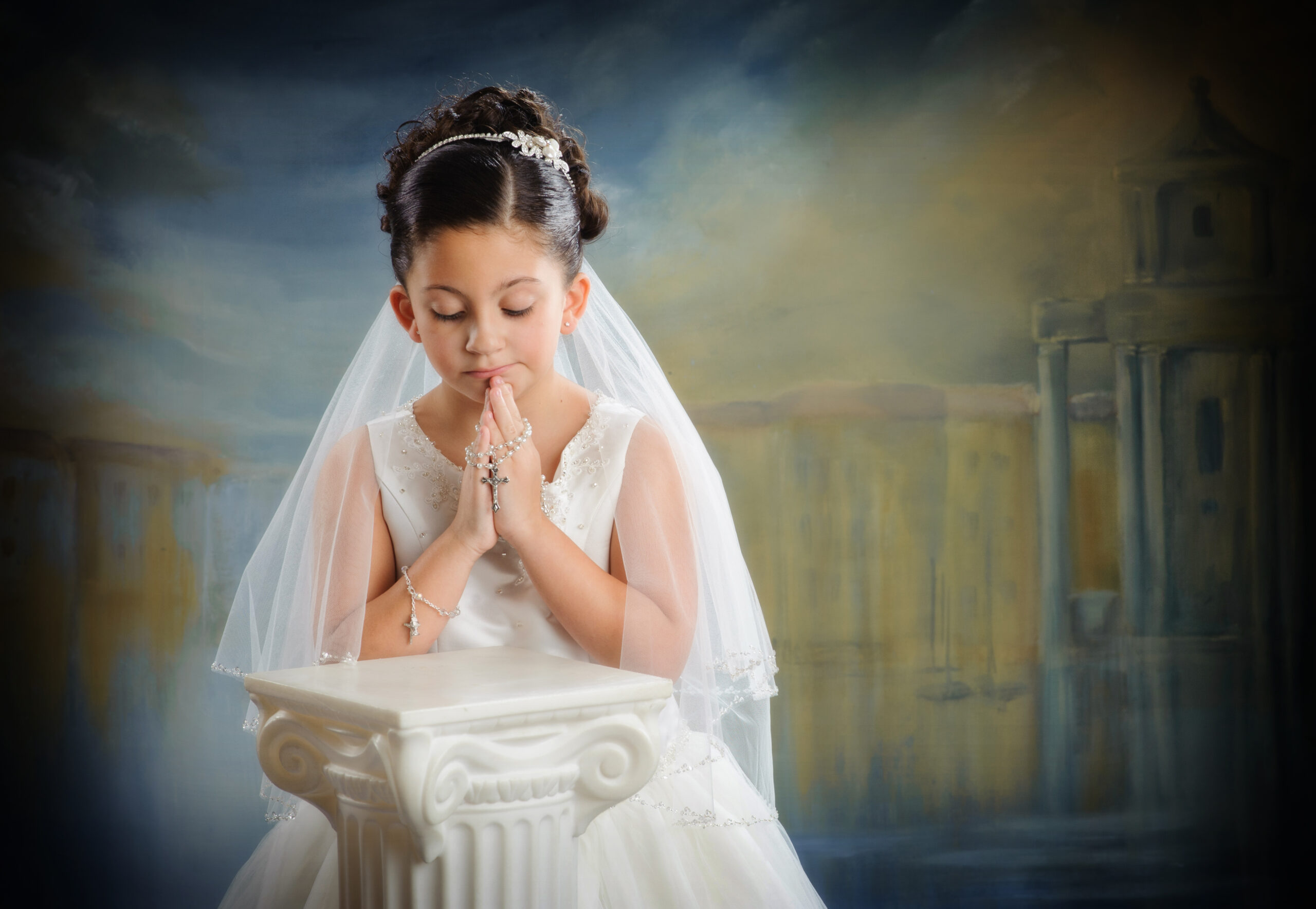 Little girl in communion dress with rosary and hands folded praying