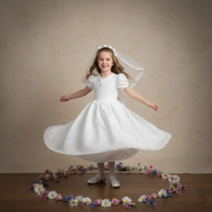 girl in communion dress twirling with flowers