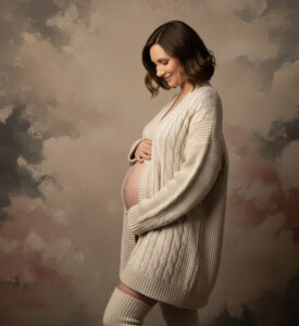 Pregnant woman in oversized soft cozy sweater with belly exposed