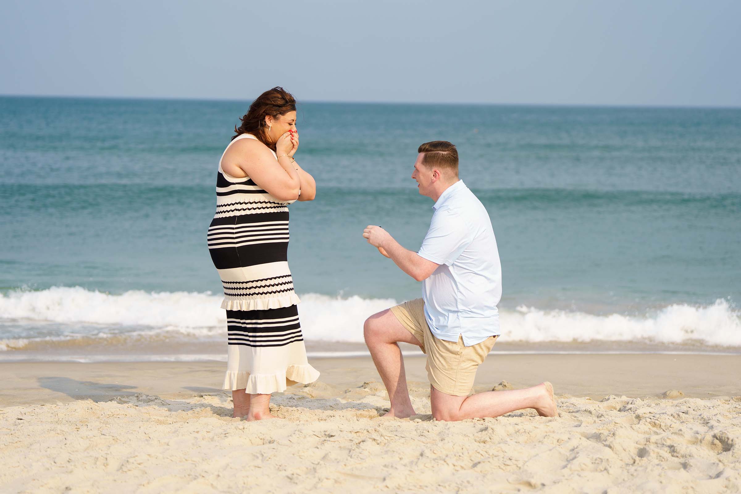 Wedding proposal on beach man on one knee
