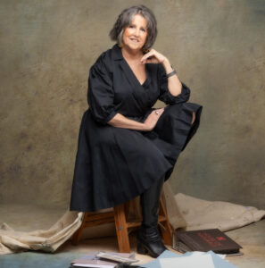 women sitting on stepstool with designer books on floor for interior design