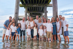 Large extended family group photo on beach under pier Avalon NJ